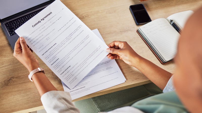 Person holding a custody agreement by the Law Offices of Robert E. O’Connor